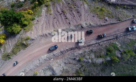 Drohnenansicht von ATV-Quads auf einem unbefestigten Pfad in Wäldern aus der Vogelperspektive. Geländewagen-Team-Club-Enthusiasten, die Spaß auf Landstraßen haben. Stockfoto
