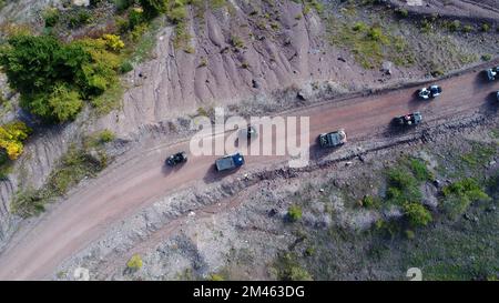 Drohnenansicht von ATV-Quads auf einem unbefestigten Pfad in Wäldern aus der Vogelperspektive. Geländewagen-Team-Club-Enthusiasten, die Spaß auf Landstraßen haben. Stockfoto