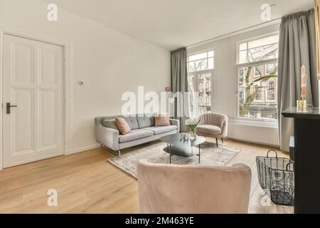Das Innere eines geräumigen Wohnzimmers in einem offenen Design mit einem großen Sofa und Teppich in einem gemütlichen Haus