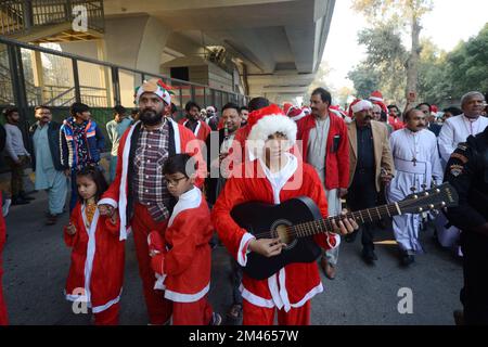 Peshawar, Pakistan. 18.. Dezember 2022. Mitglieder der christlichen Minderheit Pakistans, die als Weihnachtsmann verkleidet sind, nehmen an einer vor Weihnachten stattfindenden Rallye in einer Straße in Peshawar Teil. Pakistan ist ein muslimisches Land mit sunnitischer Mehrheit und vier Millionen Christen von einer Gesamtbevölkerung von etwa 200 Millionen Menschen. (Foto: Hussain Ali/Pacific Press) Kredit: Pacific Press Media Production Corp./Alamy Live News Stockfoto