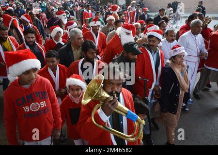 Peshawar, Pakistan. 18.. Dezember 2022. Mitglieder der christlichen Minderheit Pakistans, die als Weihnachtsmann verkleidet sind, nehmen an einer vor Weihnachten stattfindenden Rallye in einer Straße in Peshawar Teil. Pakistan ist ein muslimisches Land mit sunnitischer Mehrheit und vier Millionen Christen von einer Gesamtbevölkerung von etwa 200 Millionen Menschen. (Foto: Hussain Ali/Pacific Press) Kredit: Pacific Press Media Production Corp./Alamy Live News Stockfoto