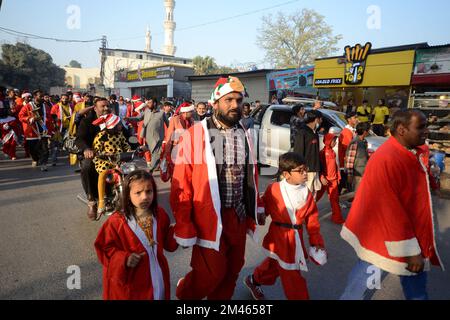 Peshawar, Pakistan. 18.. Dezember 2022. Mitglieder der christlichen Minderheit Pakistans, die als Weihnachtsmann verkleidet sind, nehmen an einer vor Weihnachten stattfindenden Rallye in einer Straße in Peshawar Teil. Pakistan ist ein muslimisches Land mit sunnitischer Mehrheit und vier Millionen Christen von einer Gesamtbevölkerung von etwa 200 Millionen Menschen. (Foto: Hussain Ali/Pacific Press) Kredit: Pacific Press Media Production Corp./Alamy Live News Stockfoto