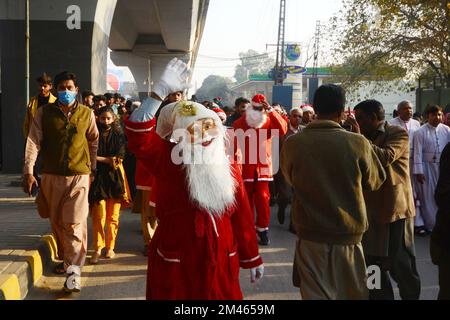 Peshawar, Pakistan. 18.. Dezember 2022. Mitglieder der christlichen Minderheit Pakistans, die als Weihnachtsmann verkleidet sind, nehmen an einer vor Weihnachten stattfindenden Rallye in einer Straße in Peshawar Teil. Pakistan ist ein muslimisches Land mit sunnitischer Mehrheit und vier Millionen Christen von einer Gesamtbevölkerung von etwa 200 Millionen Menschen. (Foto: Hussain Ali/Pacific Press) Kredit: Pacific Press Media Production Corp./Alamy Live News Stockfoto