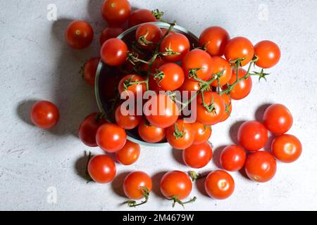 Eine Draufsicht auf saftige Kirschtomaten auf einer Schüssel auf einer Steinoberfläche Stockfoto