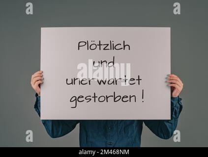 Starb plötzlich und unerwartet steht in deutscher Sprache auf dem Schild, Aufklärung der Erhöhung der Sterblichkeit, Sterberate COvid-19 Jab Stockfoto