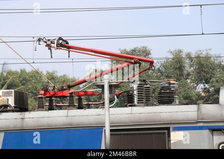 Elektrische Eisenbahnzüge mit Stromabnehmersystem, das mit Freileitungen verbunden ist, und Blick auf die elektrischen Systeme auf dem Dach Stockfoto