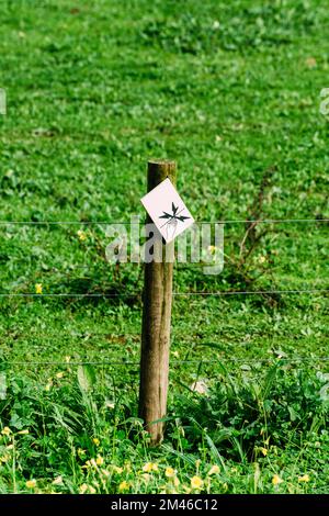 Gefahr – Schild für Elektrozaun mit geringer Schärfentiefe Stockfoto