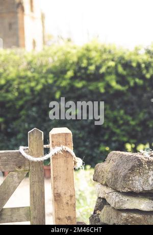 Ein Seil über einem Pfahl in einem englischen Landhaus, das aussieht, als hätten sie sich die Arme umgewickelt. Stockfoto