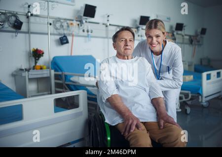 Porträt einer glücklichen Arztin mit ihrer Patientin im Rollstuhl. Stockfoto