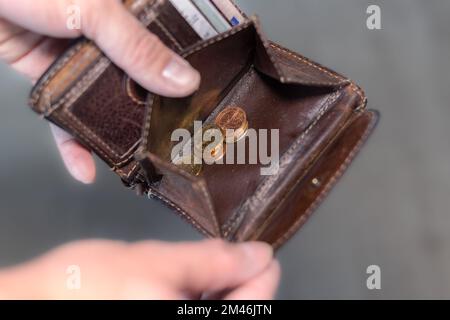 Ein Mann mit einer Brieftasche und ein paar Münzen in der Hand Stockfoto