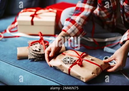 Verpackt Weihnachtsgeschenke mit braunem Papier und rotem Band. Stockfoto