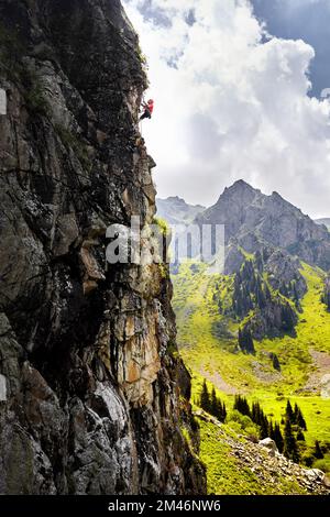 Fit starken Mann Athlet in Silhouette Klettern an der hohen vertikalen Wand an den Bergen Tyan Shan in Kasachstan Stockfoto
