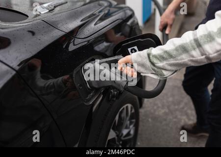 Elektroauto mit Handaufladung Stockfoto