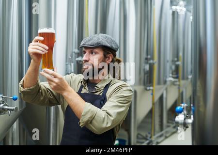 Brauer prüft die Qualität des Getränks, das er in seiner Mikrobrauerei zubereitet hat Stockfoto