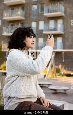 Junge Frau, die sich selbst im Spiegel betrachten Stockfoto