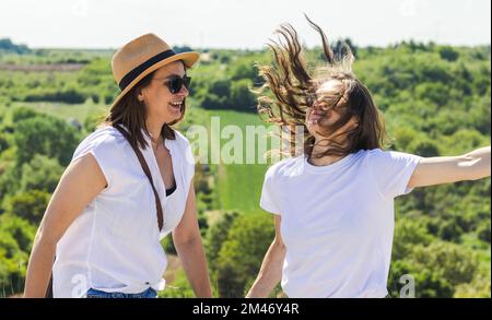 Zwei glückliche, mittelgroße Frauen, die Spaß im Freien haben. Stockfoto