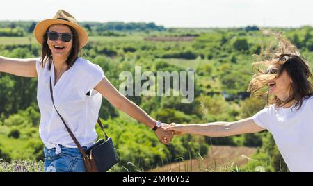 Zwei glückliche Lesben, die Spaß in der Natur haben, ein schwules Paar, das in der Natur reist. Stockfoto