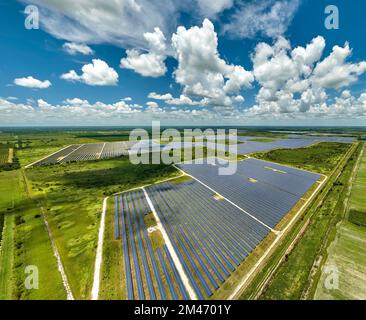 Luftaufnahme eines großen nachhaltigen Elektrokraftwerks mit vielen Reihen von Photovoltaik-Solarzellen zur Erzeugung sauberer elektrischer Energie. Erneuerbar Stockfoto