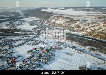 Luftaufnahme von Wohnhäusern mit schneebedeckten Dächern im ländlichen Stadtgebiet in Vororten im Winter Stockfoto
