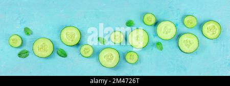 Frische Gurken- und Minzpanorama auf blauem Hintergrund, flache Aufnahmen über Kopf. Gesundes Bio-Food-Design Stockfoto