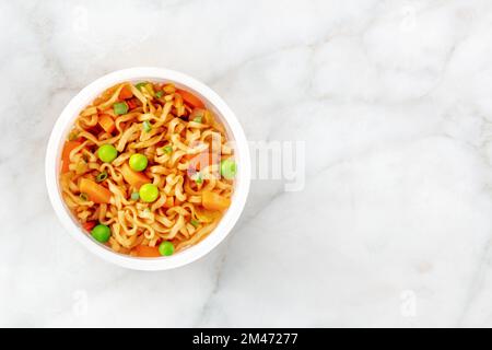 Ramen-Tasse, Instant-Soba-Nudeln in einem Plastikbecher mit Gemüse, von oben mit einem Platz für Text geschossen Stockfoto