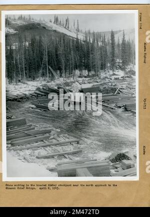 Bau Der Sikanni Chief River Bridge. Ursprünglicher Titel: Kranarbeiten auf dem behandelten Holzlagerplatz in der Nähe der nördlichen Anfahrt zur Sikanni Chief Bridge. 8. April 1943. Staat: Alaska. Stockfoto