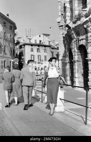 1950er Frau oder weibliche Touristin in 1950er-Mode außerhalb der Verona Arena, einem römischen Amphitheater, das 30AD erbaut wurde), auf der Piazza Bra, Verona Italien. 1957 fotografiert Stockfoto