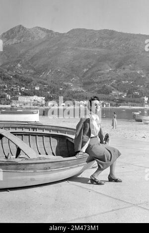 1950er Frau oder weibliche Touristin in 1950er Modeposten auf einem Holzboot in Juan oder Juan-les-Pins Antibes Alpes-Maritimes Côte-d'Azur oder an der französischen Riviera im Jahr 1955 Stockfoto