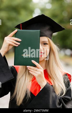 Ein Graduiertenmädchen hält ein Diplom in der Hand Stockfoto