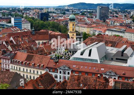 Graz, Österreich - 22. September 2022: Blick über die Hauptstadt der steiermark mit der franziskanerkirche und einem Dachgartenrestaurant Stockfoto