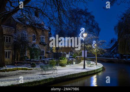 Bourton auf dem Wasser bei Nacht im Schnee. Bourton on the Water, Cotswolds, Gloucestershire, England Stockfoto