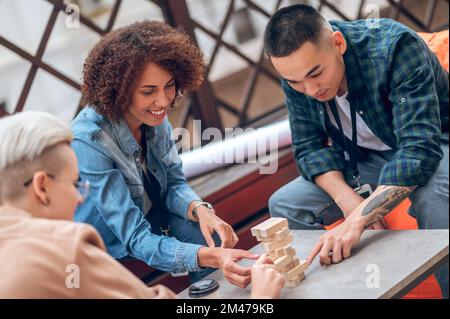 Drei junge Erwachsene spielen ein Brettspiel Stockfoto