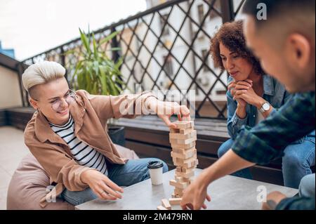 Gesellschaft von drei Personen, die an einem Brettspiel beteiligt sind Stockfoto