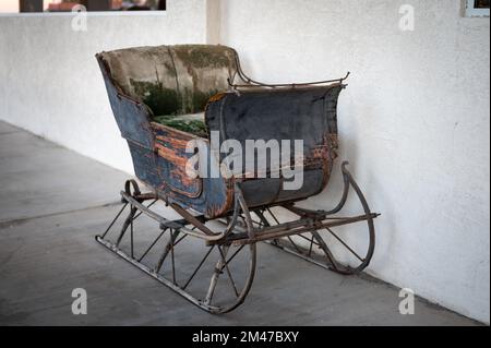 Ein alter Holzschlitten, er liegt auf der Veranda eines Hauses Stockfoto