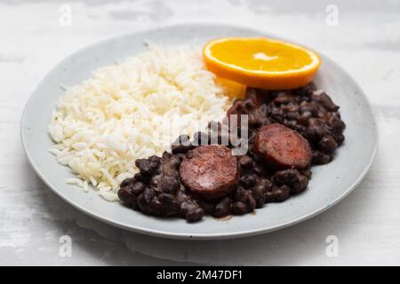 Typisch brasilianische Essensbohnen mit Würstchen und Reis Feijoada auf weißem Gericht Stockfoto