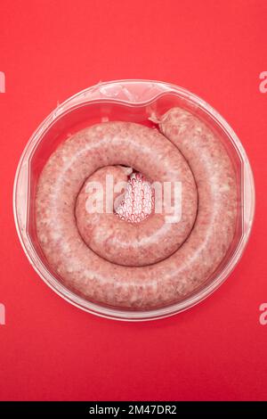 Gerolltes Botifarra, eine für Katalonien typische Schweinefleischwurst, in einem Plastik Stockfoto