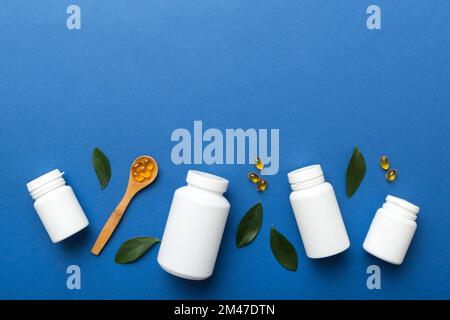 Omega-3 Kapseln liegen in einer weißen Flasche auf einem Tisch mit grünem Blatthintergrund. Fischöltabletten. Biologisch aktive Zusatzstoffe. omega 6, Omega 9, Vitam Stockfoto