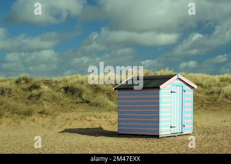 Einzelne Strandhütte an einem Sandstrand mit Sanddünen. Stockfoto