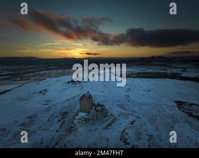 Luftaufnahme des Smailholm Tower mit Blick auf die Eildons bei Sonnenuntergang an einem frischen, frostigen Wintertag. Stockfoto