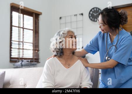 Junge Pflegekraft, die Seniorin hilft. Krankenschwester, die ihre alte Patientin in der häuslichen Krankenpflege unterstützt Stockfoto
