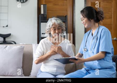 Junge asiatische Krankenschwester, betreutes Wohnen, Pflegekraft oder Arzt besuchen ältere Senioren zu Hause Sprechen Sie über die Checkliste für die Ergebniskontrolle Stockfoto