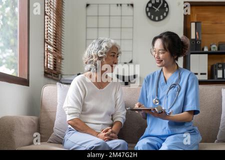 Gesundheitspersonal oder Pflegekraft besucht Seniorin zu Hause, erklärt Medikamentendosierung Stockfoto