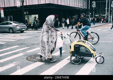 New York Manhattan, 02,10 - 10.10.22: Eine ältere Frau geht mit einem kleinen Wagen über einen Zebrastreifen. Foto: pressefoto Mika Volkmann Stockfoto