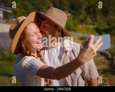 Konzept der Frischluft und der Teilnahme an Aktivitäten im Freien. Ein paar verliebte Studenten lächeln und machen Selfie-Fotos mit einer Smartphone-Kamera, während sie im Urlaub durch die Türkei reisen Stockfoto