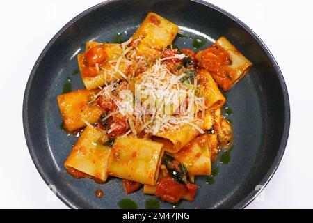 Authentische mediterrane Pasta mit italienischem Paccheri-Käse und frischer Tomatensauce aus nächster Nähe Stockfoto