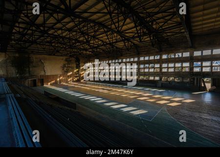 Große alte, ruinierte Turnhalle in einer verlassenen Schule. Stockfoto