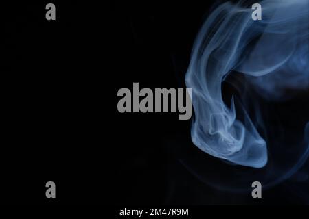 Anmutige Wirbel aus weißem Rauch, isoliert von schwarzem Hintergrund. Nahaufnahme von Dampf. Weichzeichner und Textur von Helios 44m-4-Objektiv im Vintage-Design. Abstrakte Graphik Stockfoto