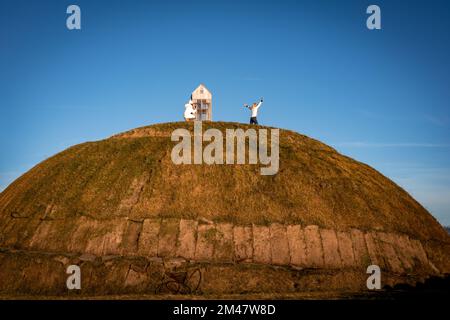 Reykjavik, Island - 25. November 2022: Thufa rund um den Grashügel an der Meeresküste von Grandi. Touristen machen Fotos auf dem Hügel. Stockfoto