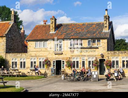 Die Menschen von Hutton le Hole North Yorkshire saßen vor dem Crown Pub auf dem Grün in Hutton le Hole Yorkshire UK GB Europa Stockfoto