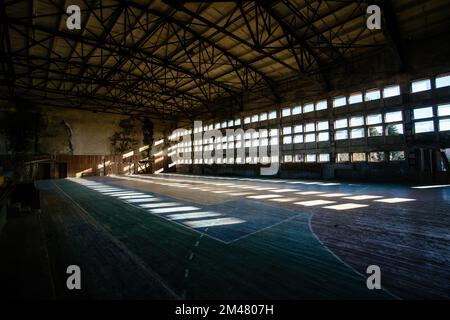 Große alte, ruinierte Turnhalle in einer verlassenen Schule. Stockfoto